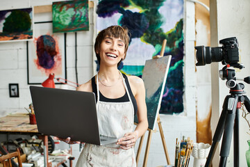 A woman confidently stands in front of a laptop computer. © LIGHTFIELD STUDIOS