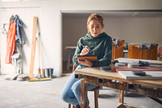 Female Worker In Concrete Workshop Using Digital Tablet And Stylus
