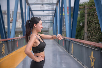 woman doing run exercise in the park.  sport woman with check smart watch.