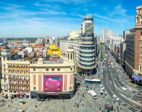 Madrid, Spain - March 10, 2024. Aerial view of Gran V&iacute;a, featuring the iconic Capitol Building with the Schweppes sign, bustling with traffic and pedestrians on a clear day. View from Callao square.