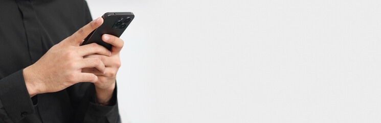 Man typing message on mobile phone against light background, closeup. Banner design with space for text