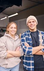 Portrait Of Smiling Male And Female Workers Standing In Doorway Of Concrete Workshop 