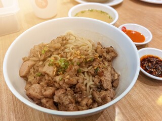 Tao Si Chicken Noodles served in a plate on a wooden table with a view of Hong Kong fast food