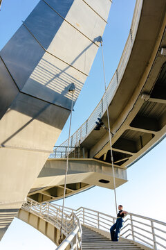 Person spending time under modern urban bridge