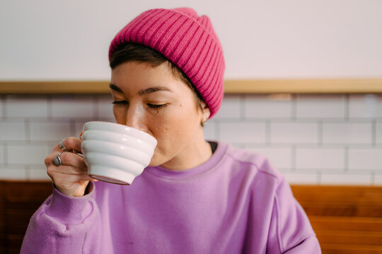 A woman drinks coffee in a cafe