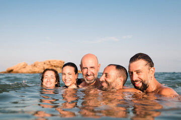 Cheerful friends having fun together in the sea