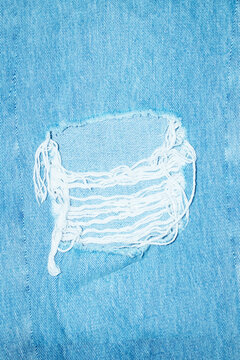 Close-up of ripped denim fashion style jeans with direct flashlight