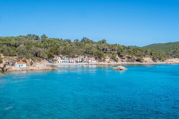 Obraz premium Aerial view of a small Mediterranean fishermen neighborhood, on the shore of a rocky beach. Cala S'alguer, Palamos, Costa Brava, Girona, Catalonia, Spain