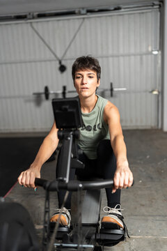 Woman Exercising on Rowing Machine in Home Gym