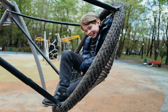 Young Boy Enjoying Tire Swing in the Outdoors
