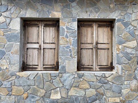 Two closed windows into the cobble wall.