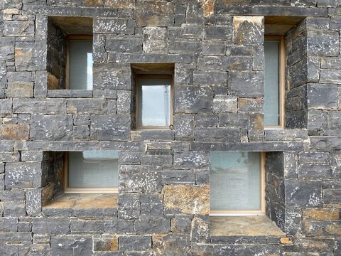 Five windows are deeply embedded in the stone wall.