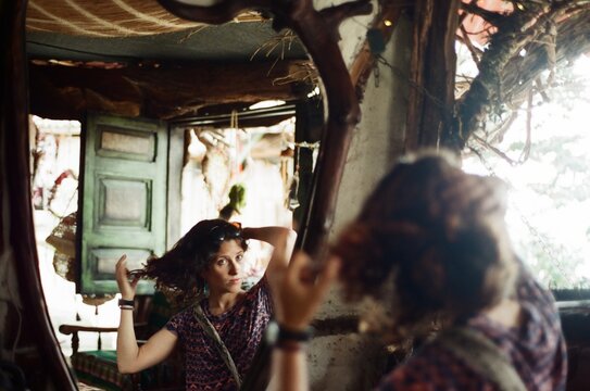 young woman looking at her reflection in the mirror