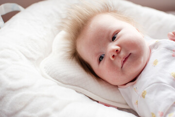 Portrait of a 1-month-old newborn baby girl. Caucasian baby in a baby nest