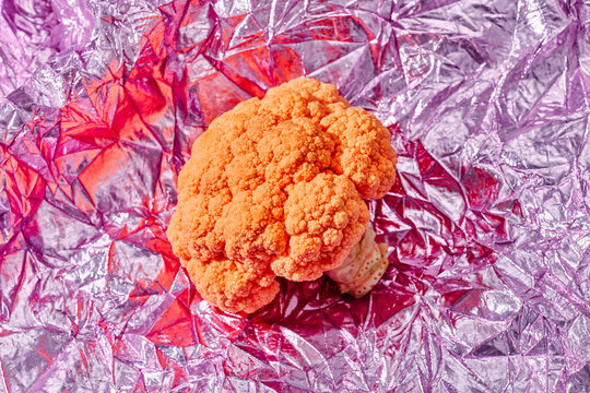 orange cauliflower on a pink fabric