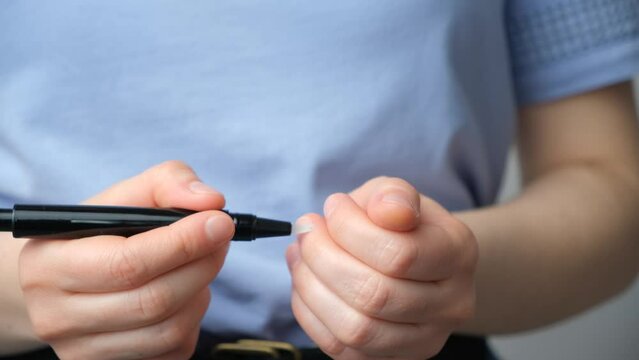 A woman applies natural cuticle oil to the cuticle. Nail care