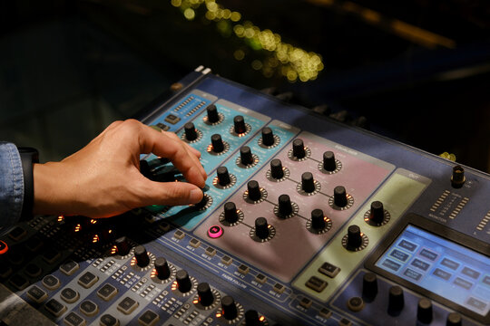 Sound Engineer's Hands On Mixer Board Faders