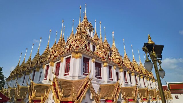 Time lapse scenery The metallic castle covered with gold leaf at of Ratchanatdaram Worawihan.
The Golden castle with spire at Wat Loha Prasat.amazing building with an iron roof made of 37 spires