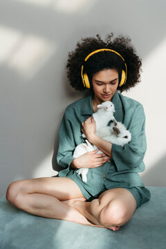Woman Sitting on Sofa Holding Cute Rabbits