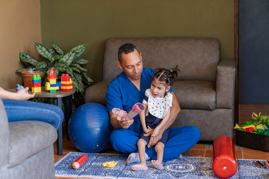 Man physiatrist showing braces equipment to girl