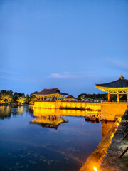 Obraz premium A beautiful lake with a bridge and a building in the background. The water is calm and the sky is clear