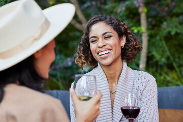 Girlfriends laughing drinking wine together