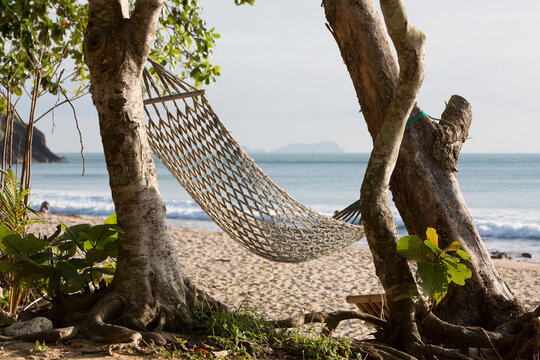 A string hammock strung between two trees
