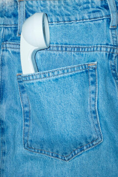 Landline phone in a pocket of blue denim jeans with hard flashlight