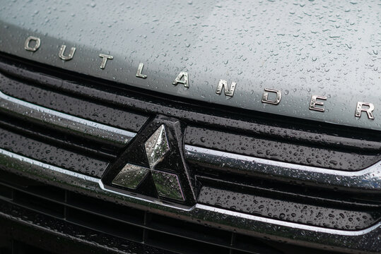 Kyiv, Ukraine - May 24, 2024. Mitsubishi Outlander sign on the grille of a car with water drops 