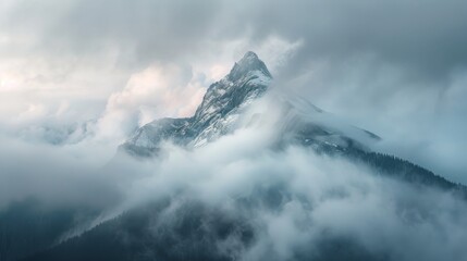 Dramatic mountain peak covered in fog and snow