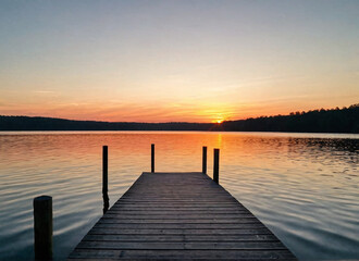 Sunset over a serene lake with a dock