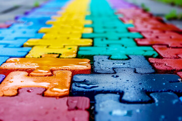 Close-up images of colorful puzzle pieces, each featuring different vibrant colors and textures, arranged in various patterns to symbolize autism awareness.