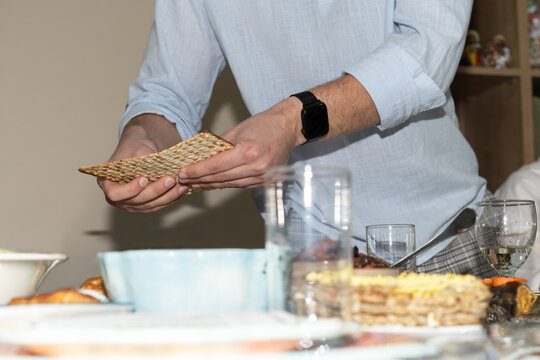 Man Breaking Matzah During Passover Seder.