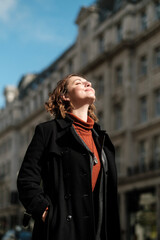 Relaxed woman is enjoying sunlight in a London street.