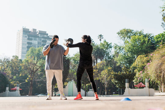 Multiracial couple in the park exercising.