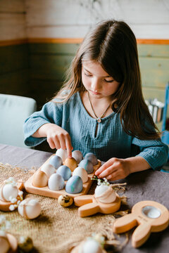 Little girl with painted and decorated Easter eggs, counting them