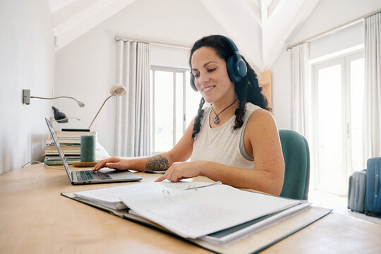 Smiling student in headphones checking notes