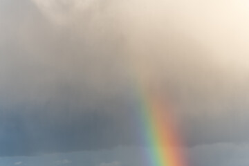 Rainbow appearing in rainy clouds in spring.