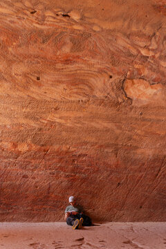 Man eading a book in Sandstone cave, Petra, travel Jordan