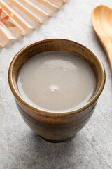 Single cup of Japanese kuro Amazake, fermented rice drink close up