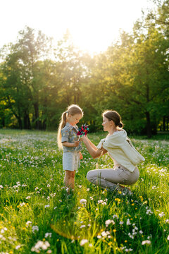Mother fastening daughter's jacket in nature