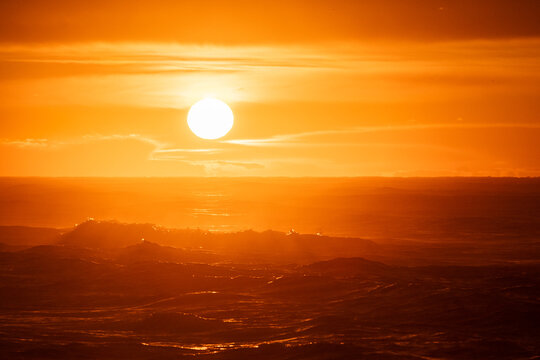 Dramatic orange sunrise on beach.