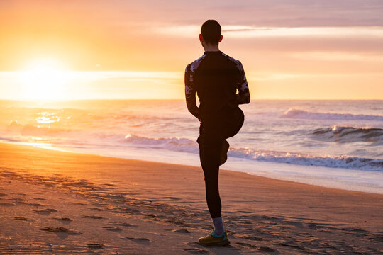 Straching before morning run on the beach.