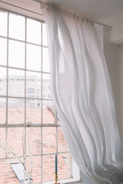 Elegant white curtains draping by window