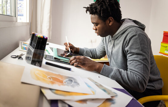 Teenage designer works on drawing desk