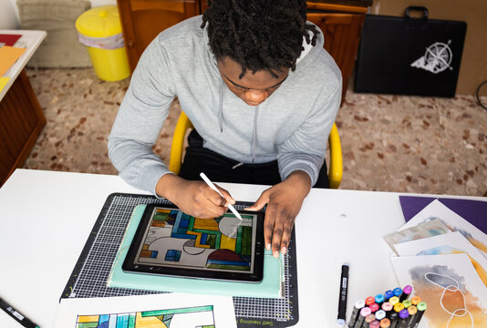 Top view of teen working on digital design.