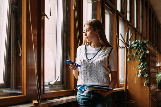 Student with textbooks and phone 