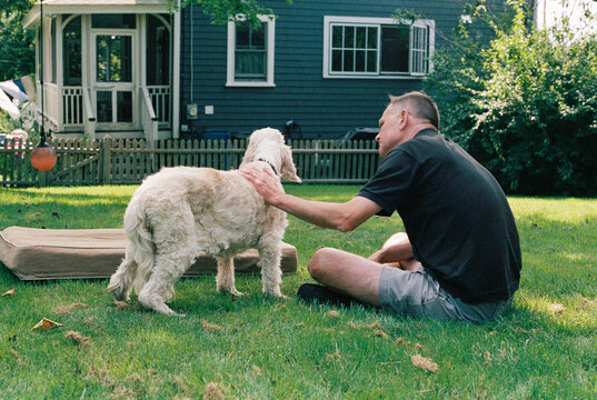 Man Tenderly Pets his Old Dog who is about to be Put to Sleep