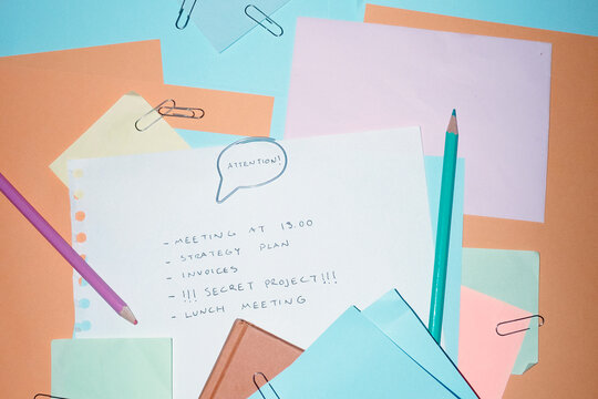 Colourful office supply and speech bubble paper clip saying attention