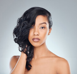 Hair care, woman and serious in studio for beauty with curly treatment, shampoo shine or glowing...